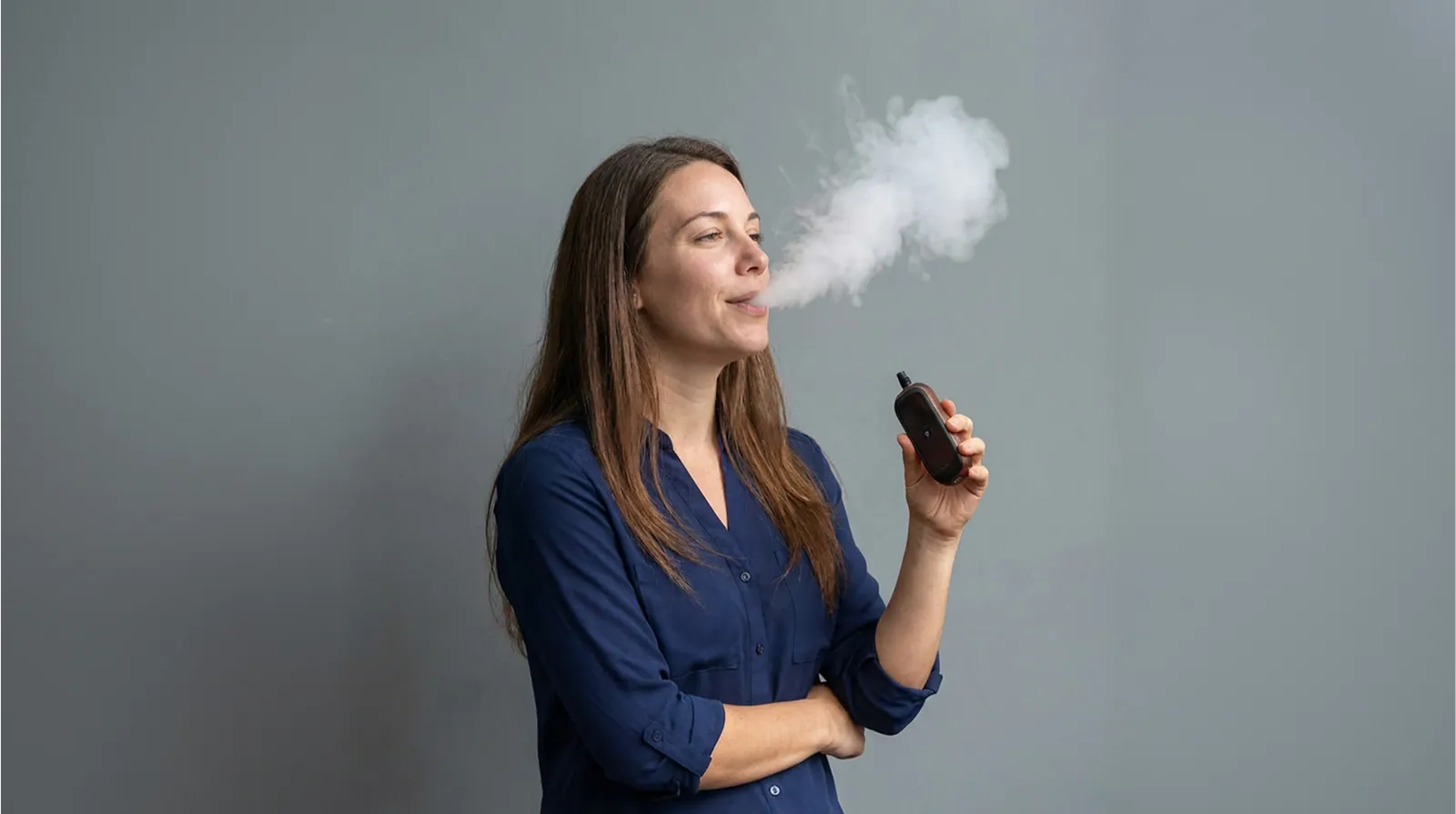 Woman exhaling a light cloud of vapor