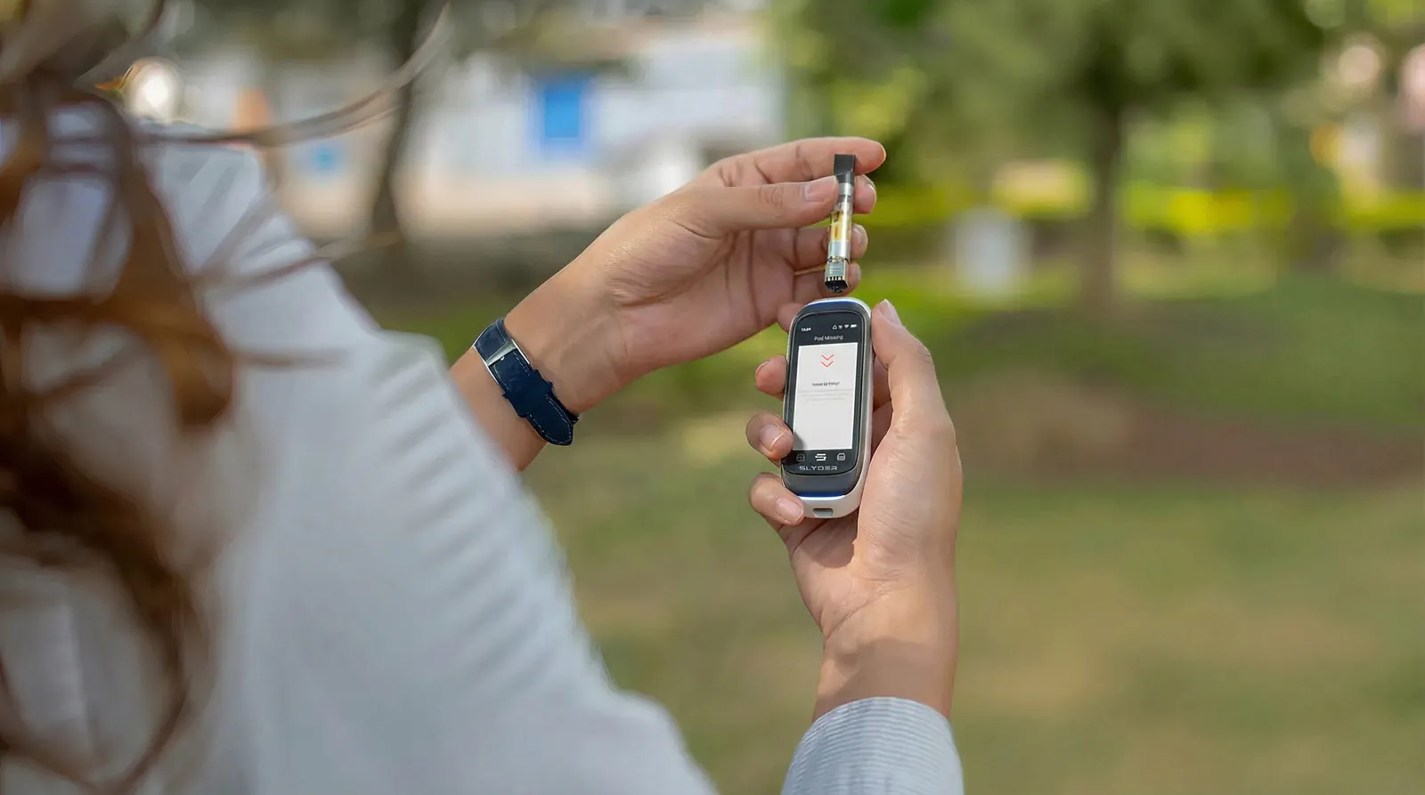 Woman holding Slyder Pro with a 510 cartridge in a park